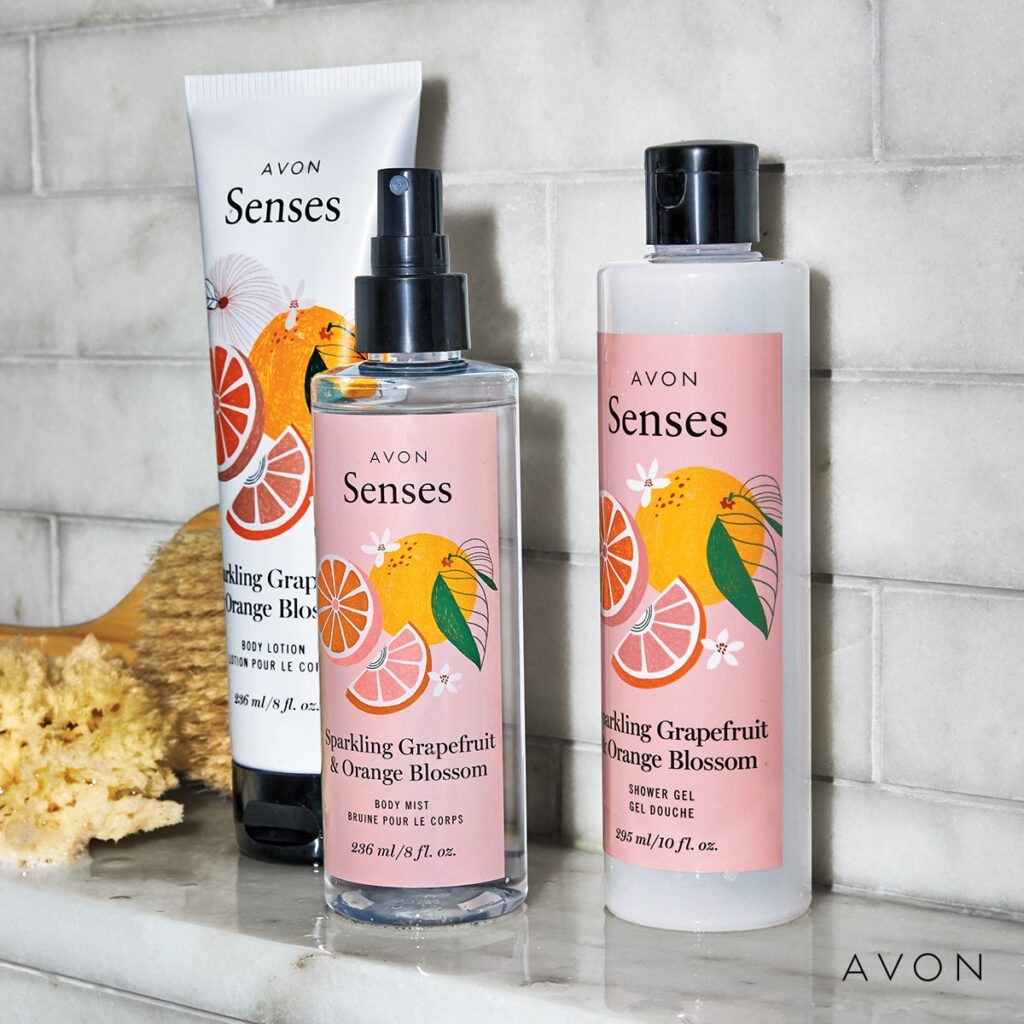 Avon Senses Sparkling Grapefruit & Orange Blossom Body Lotion, Body Mist and Shower Gel on a marble shelf with sponge and wooden brush