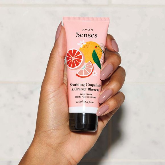hand holding tube of Avon Senses Sparkling Grapefruit & Orange Blossom Hand Cream