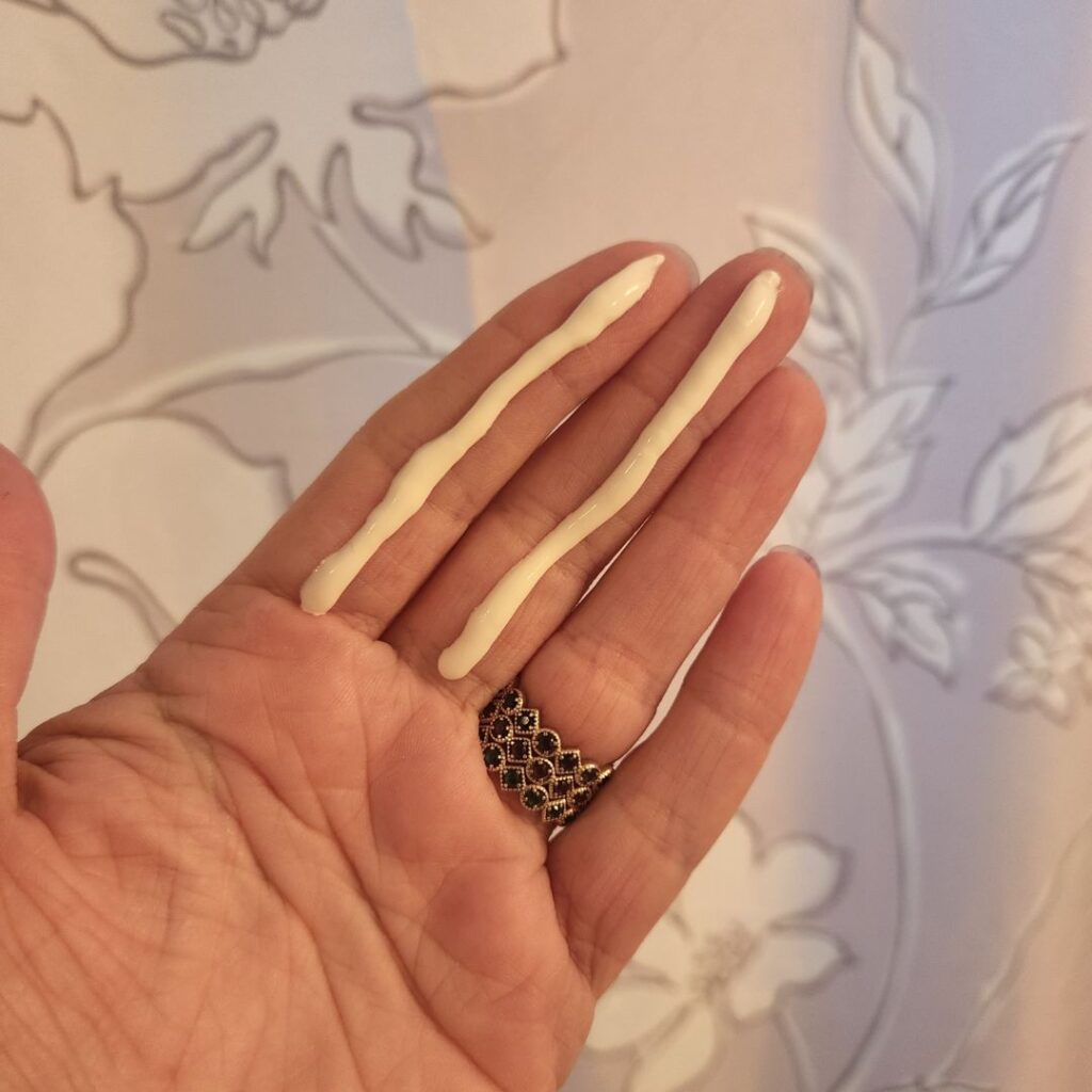 two lines of sunscreen on pointer and middle finger