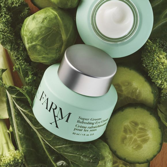 2 jars of Farm Rx Super Greens Refreshing Eye Cream on a bed of green vegetables