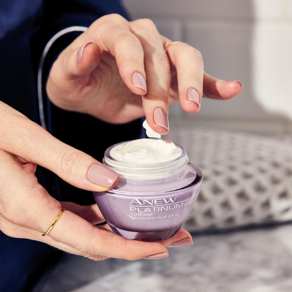 hands holding a jar of Anew Platinum Day Cream 